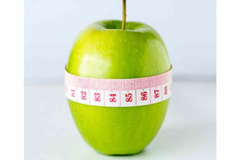 یک سیب که سانتی متر به دو آن پیچیده شده و اشاره به لاغری با متخصص تغذیه دکتر معصومه مرادی دارد