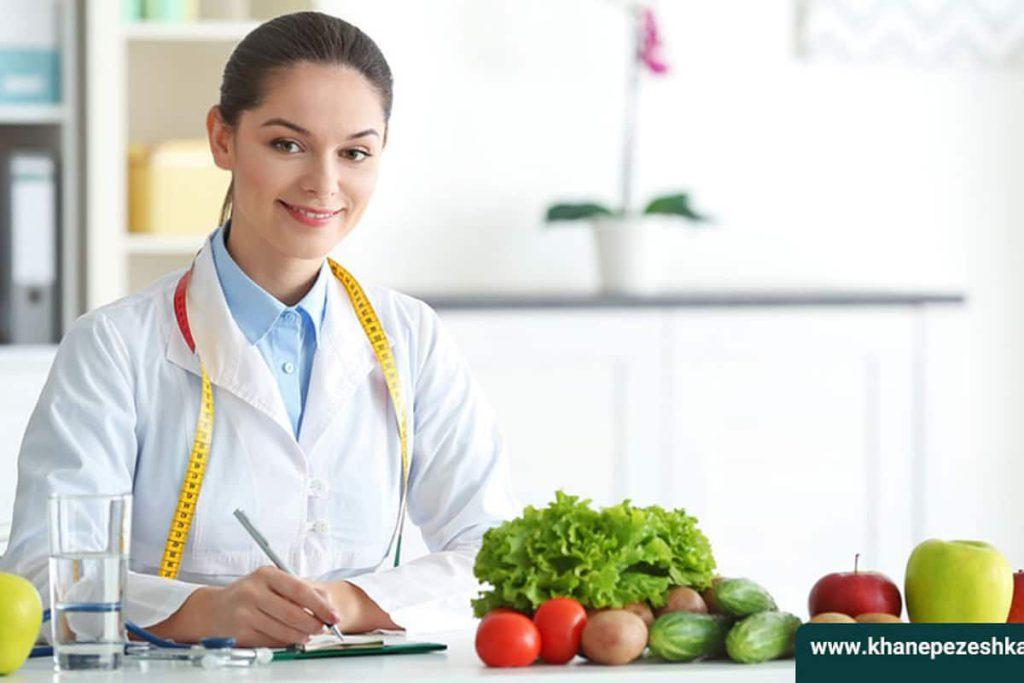 حیطه کاری کارشناس تغذیه دکتر درحال نوشتن رژیم و روی میز سبزیجات قرار دارند