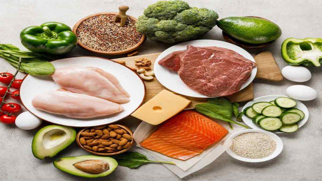 خوراکی های مصرفی در هفته اول رژیم کتوژنیک رایگان تصویر گوشت قرمز و سفید، ماهی سالمون، کره، آووکادو، خیار، تخم مرغ، آجیل و دانه ها، کلم بروکلی، فلفل دلمه ای، کره و گوجه فرنگی را در هفته اول رژیم کتوژنیک رایگان 28 روزه نشان می دهد.