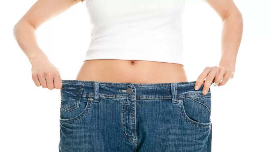 لاغری شکم یک خانم که با گشاد شدن شلوار آن را نمایش می دهد و به هزینه امبدینگ لاغری و فواید امبدینگ شکم اشاره دارد