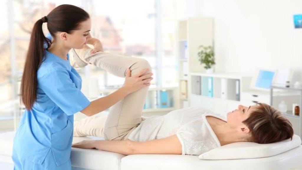 متخصص طب فیزیکی و توانبخشی در غرب تهران-متخصص طب فیزیکی و توانبخشی چیست؟ دکتر در حال ورزش دادن و توانبخشی پا یک بیمار که به متخصص طب فیزیکی و توانبخشی در غرب تهران و متخصص طب فیزیکی و توانبخشی چیست؟ اشاره دارد